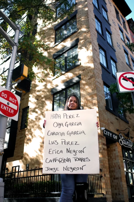 Woman holding a hand-written sign.